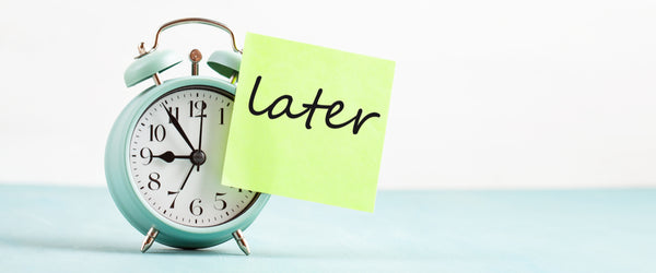 Alarm clock with note that says "later"