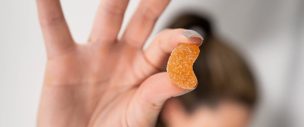 Hand holding a CBD gummy