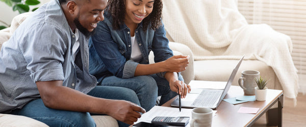 Couple sitting on couch creating a budget