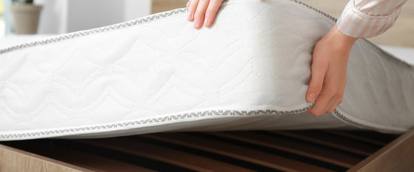 Woman lifting mattress to rotate