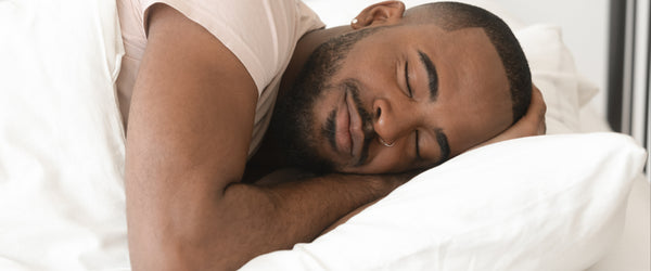 Man sleeping with pillow and comforter
